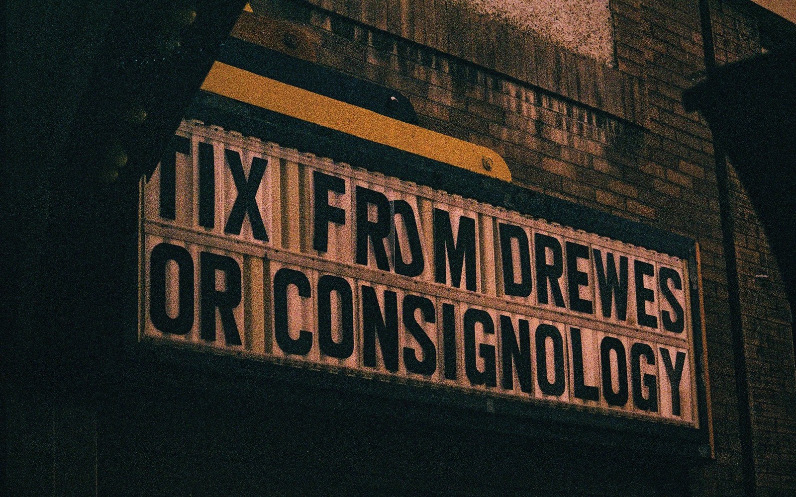 A 1950s cinema marquee lit at night advertising a creature-feature double bill