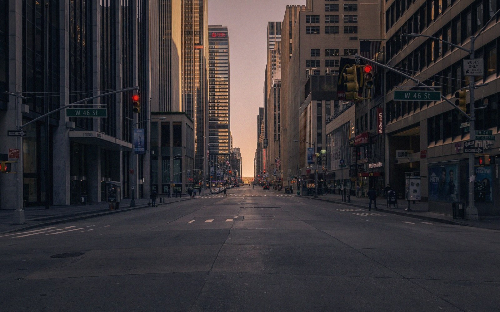 Empty W 46th Street in Manhattan flanked by skyscrapers at dusk